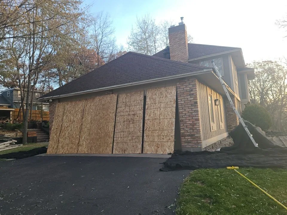 Plywood protection covering the garage doors beneath a roof