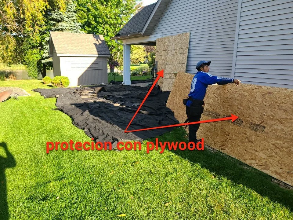 Plywood and protective coverings around the planting bed next to a house