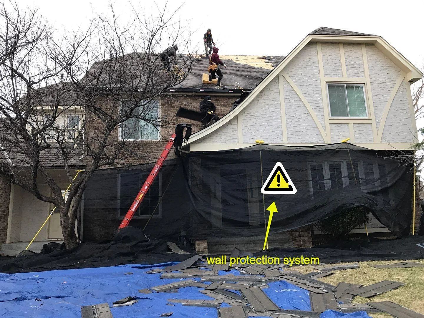 Tarps and protective wall covering below the windows of a two-story house